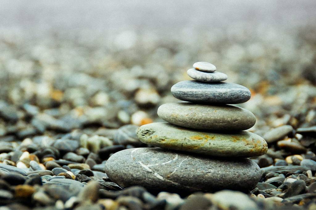 A stack of rocks on the ground with some water