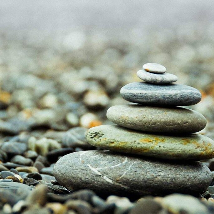 A stack of rocks on the ground with some water