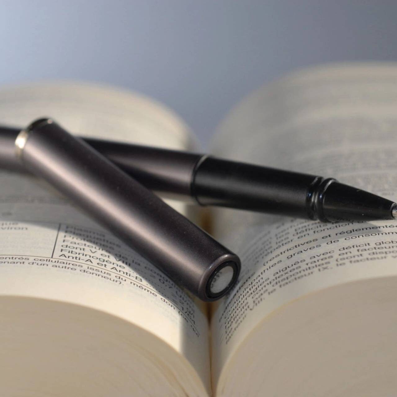 A pen and pencil sitting on top of an open book.